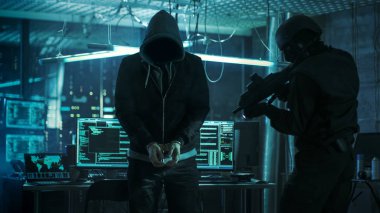 Ayakta ve silahlı olarak yeniden tarafından korunan kelepçeli maskeli Hacker olduğunu 