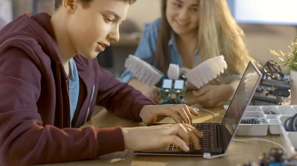 Robot completamente funzionale del programma della ragazza e del ragazzo con il computer portatile per Thei — Foto Stock