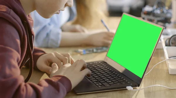 Smart Young Boy trabaja en un ordenador portátil con pantalla verde simulada en H —  Fotos de Stock