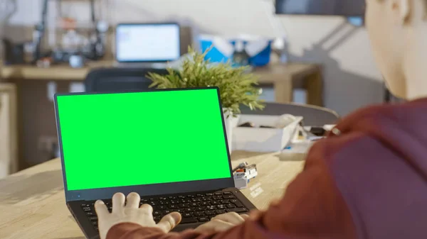 Rapaz inteligente usa laptop com tela verde Mock-up em seu computador — Fotografia de Stock