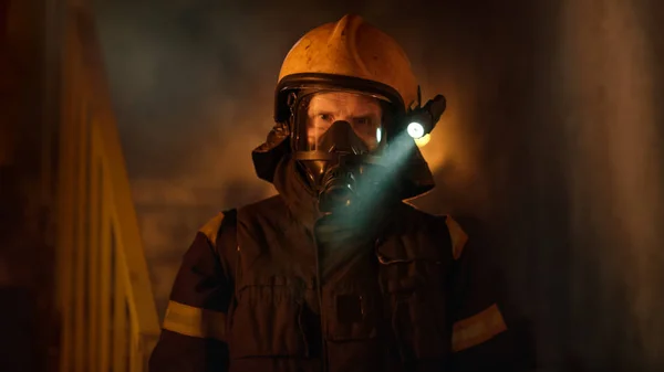 Porträtt skott av en modig brandman står i en brinnande byggnad — Stockfoto