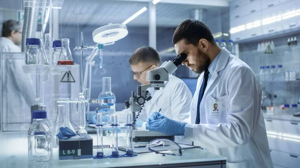 Em um laboratório moderno dois cientistas conduzem experimentos. Chefe. — Fotografia de Stock