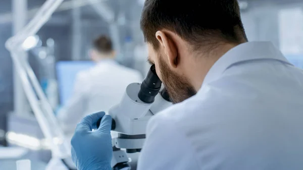 Взгляд на плечо ученого-исследователя, изучающего микр — стоковое фото