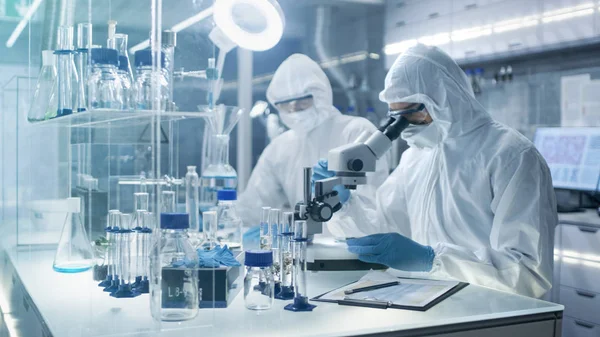 En un laboratorio seguro de alto nivel Científicos en un Condu Coverall —  Fotos de Stock