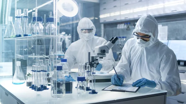 Em um laboratório de alto nível seguro Cientistas em uma Coverall Condu — Fotografia de Stock