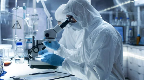 In een veilige hoge niveau laboratorium wetenschappers in een overall Condu — Stockfoto