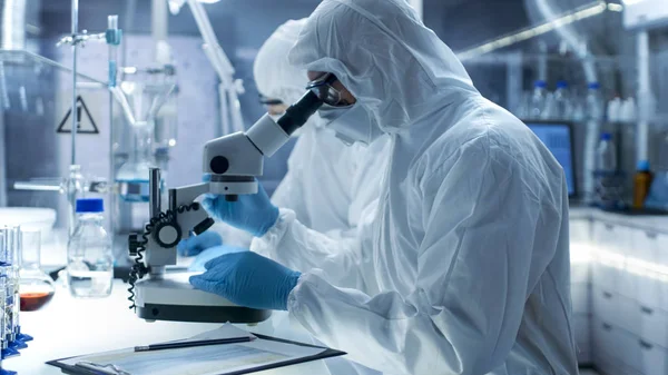 Em um laboratório de alto nível seguro Cientistas em uma Coverall Condu — Fotografia de Stock