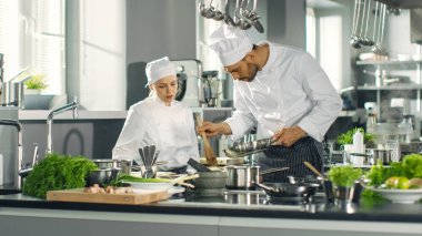 Ünlü şef ve onun kadın çırak hazırlamak özel tabak içinde bir 