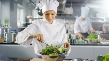Ünlü bir restoranda kadın aşçı salatası hazırlar. O çalışıyor 
