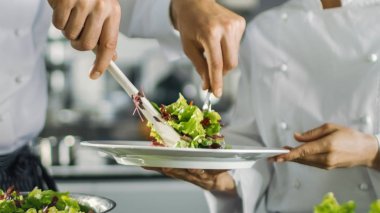 Bir ünlü restoran aşçı salatası hazırlar ve bir Plat koyar