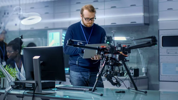 Jeune Homme Ingénieur Programmes Drone tout en tenant ordinateur portable dans son H — Photo