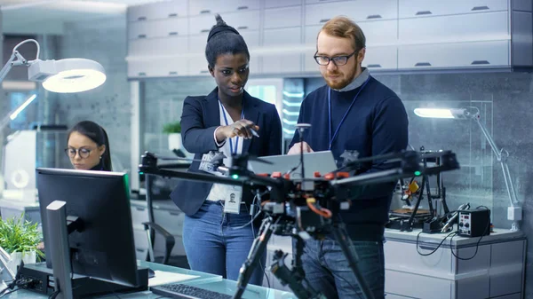 Kaukasische männliche und schwarze Ingenieurinnen arbeiten an einem Drohnenprofi — Stockfoto