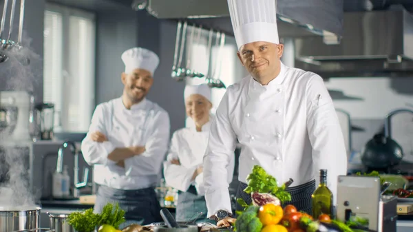 Berühmter Koch eines großen Restaurants bereitet Gerichte zu und lächelt auf ca. — Stockfoto
