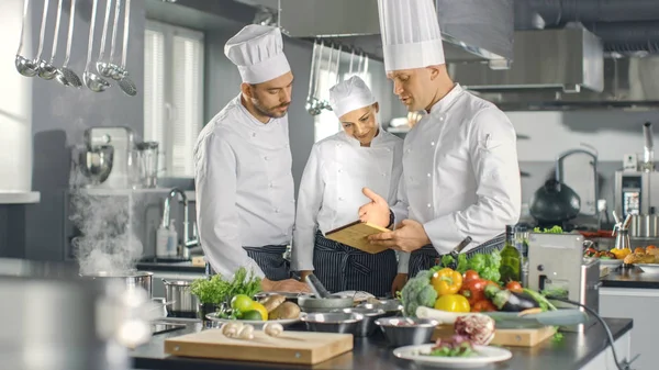 Na moderna equipe de cozinha dos cozinheiros Use Tablet Computer para Reci — Fotografia de Stock