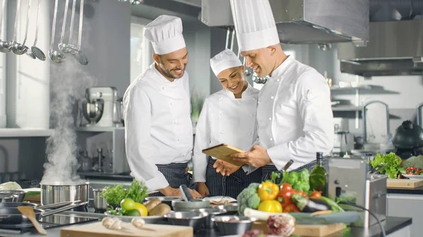 In de moderne keukenteam van koks gebruikt Tablet PC voor Reci — Stockfoto