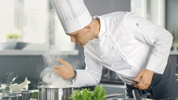 O famoso chef do restaurante cheira a vapor da panela. Sua preparação — Fotografia de Stock