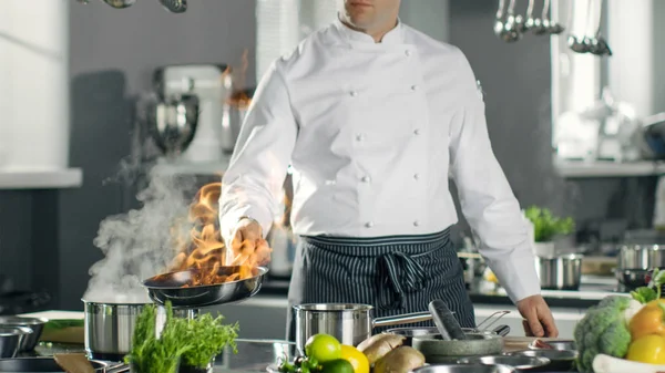 Chef profesional enciende aceite en una sartén. Cocina estilo Flambe. H —  Fotos de Stock