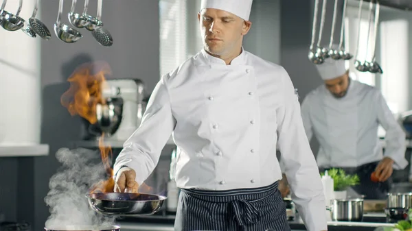 Chef profissional incendeia óleo em uma panela. Estilo Flambe Cozinhar. H — Fotografia de Stock