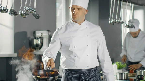 Профессиональный шеф-повар запускает масло на сковороде. Приготовление пищи в стиле фламб. H — стоковое фото
