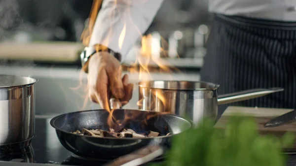 Profi-Koch kocht Flammenstil. er bereitet Gericht in einer Pfanne zu — Stockfoto