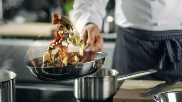 Chef cuisinier professionnel cuisine style flambe. Il prépare un plat dans une casserole — Photo