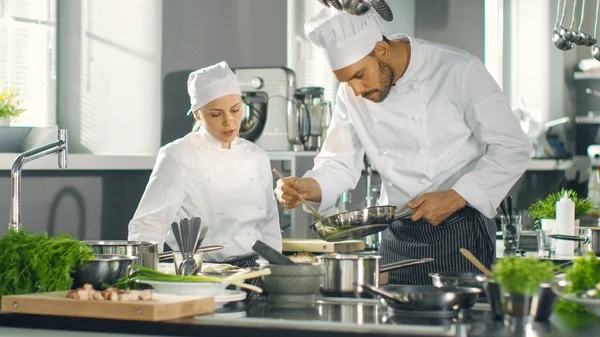 Beroemde chef-kok en zijn vrouwelijke leerling bereiden speciale schotel in een — Stockfoto