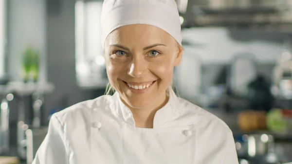 Porträt einer jungen Köchin, die beim Kochen in einem modernen Restaurant lächelt — Stockfoto