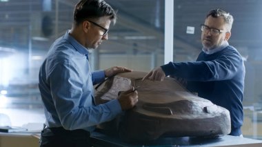 İki erkek otomotiv tasarımcısı yeni Gen bir kil modelinde çalışma