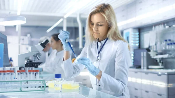 Vrouwelijke onderzoek wetenschapper gebruik micropipet vullen Test ik buizen — Stockfoto
