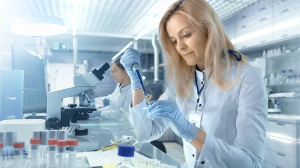 Vrouwelijke onderzoek wetenschapper gebruik micropipet vullen Test ik buizen — Stockfoto