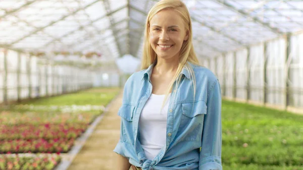 Shot of Beautiful Blonde Gardener Stands Smiling in a Greenhouse — Stock Photo, Image