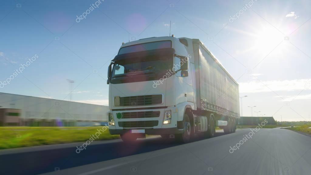 Big White Semi Truck with Cargo Trailer Moves on the Industrial 