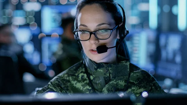 Primer plano de la mujer oficial del ejército usando la computadora en los auriculares — Foto de Stock