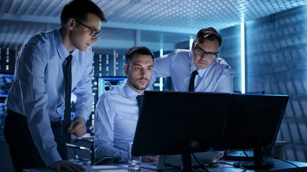 Three Operations Engineers Solving Problem in a Monitoring Room. Royalty Free Stock Photos