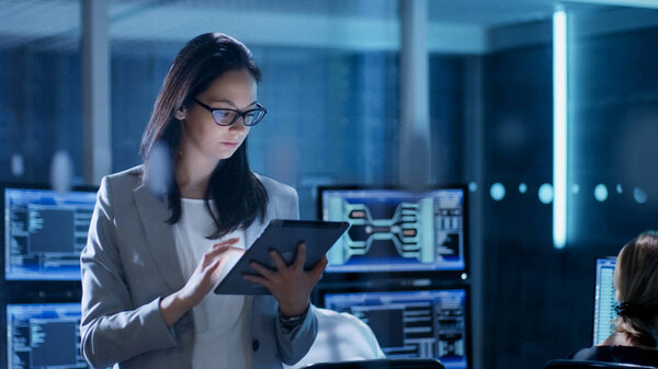 Young Female Government Employee Wearing Glasses Uses Tablet in Royalty Free Stock Images