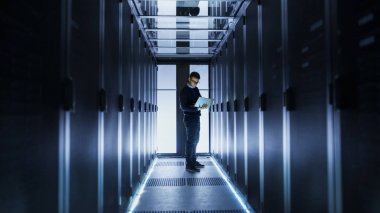 Erkek mühendis çalışır bir koridor sonundaki bir dizüstü bilgisayarda bir