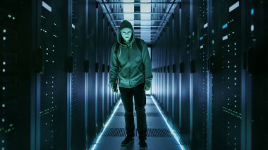 Atış veri merkezi ile ayakta kapüşonlu bir maskeli hacker