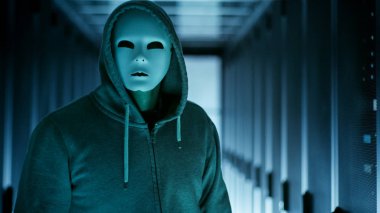 Maskeli Hacker bir Hoodie kameraya izlerken. Bir veri içeriyor
