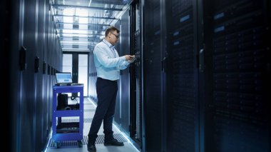 IT Engineer Installing Hard Drives into Working Rack Server. He'