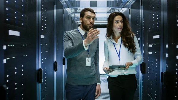 Инженер по информационным технологиям показывает женскому персоналу центр обработки данных / серверную комнату — стоковое фото