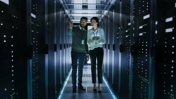 Инженер по информационным технологиям показывает женскому персоналу центр обработки данных / серверную комнату — стоковое фото