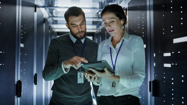 Deux ingénieurs informatiques marchent dans le centre de données / salle de serveurs, parler , — Photo