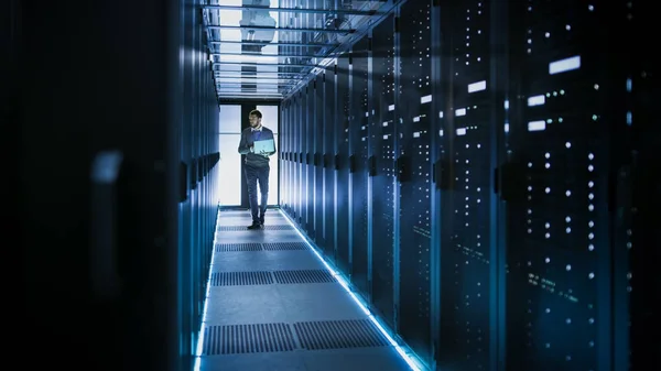 Techniker arbeitet an Laptop in großem Rechenzentrum voller Racks — Stockfoto