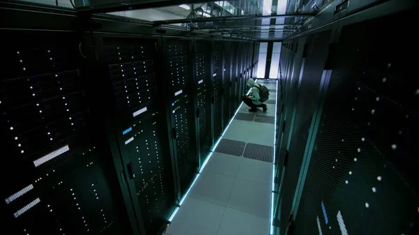 Câmera de segurança vista de um Hacker com capuz no Data Center, com o seu — Fotografia de Stock