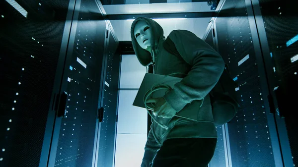 Снимок хакера в маске в капюшоне, пробирающегося через С — стоковое фото