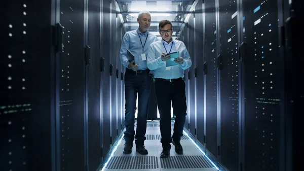 Em Data Center Dois engenheiros de TI caminhando pelas linhas do servidor R — Fotografia de Stock