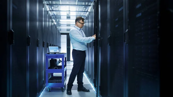 IT Engineer Installing Hard Drives into Working Rack Server. He' — Stock Photo, Image