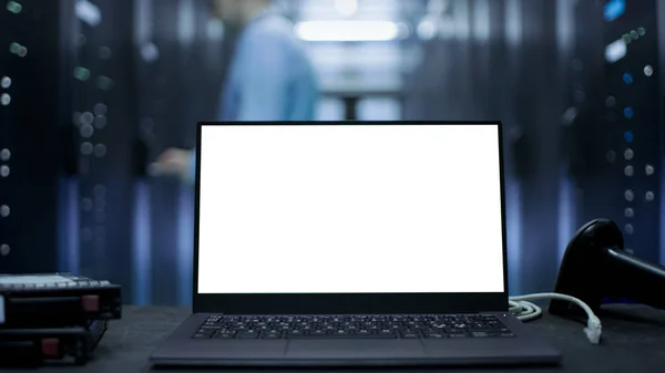 Ноутбук з білий екран на ньому стоїть на столі. У на захованих — стокове фото