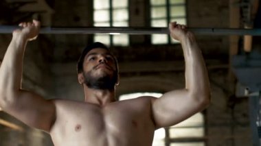 Kaldırma ağır Halter ve işin askeri basın vücut geliştirme egzersiz sanayi spor salonu binanın içinde bir kas gömleksiz adam Close-Up.