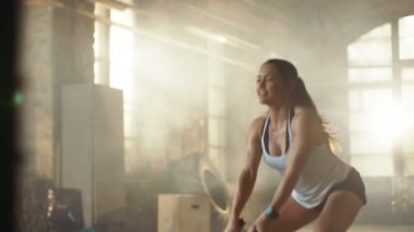 Bir spor salonunda atletik erkek egzersizleri ile savaş ipler onun çapraz Fitness Egzersiz sırasında / yoğun aralığı eğitim. O kas ve terli, spor salonu sanayi yapılar.